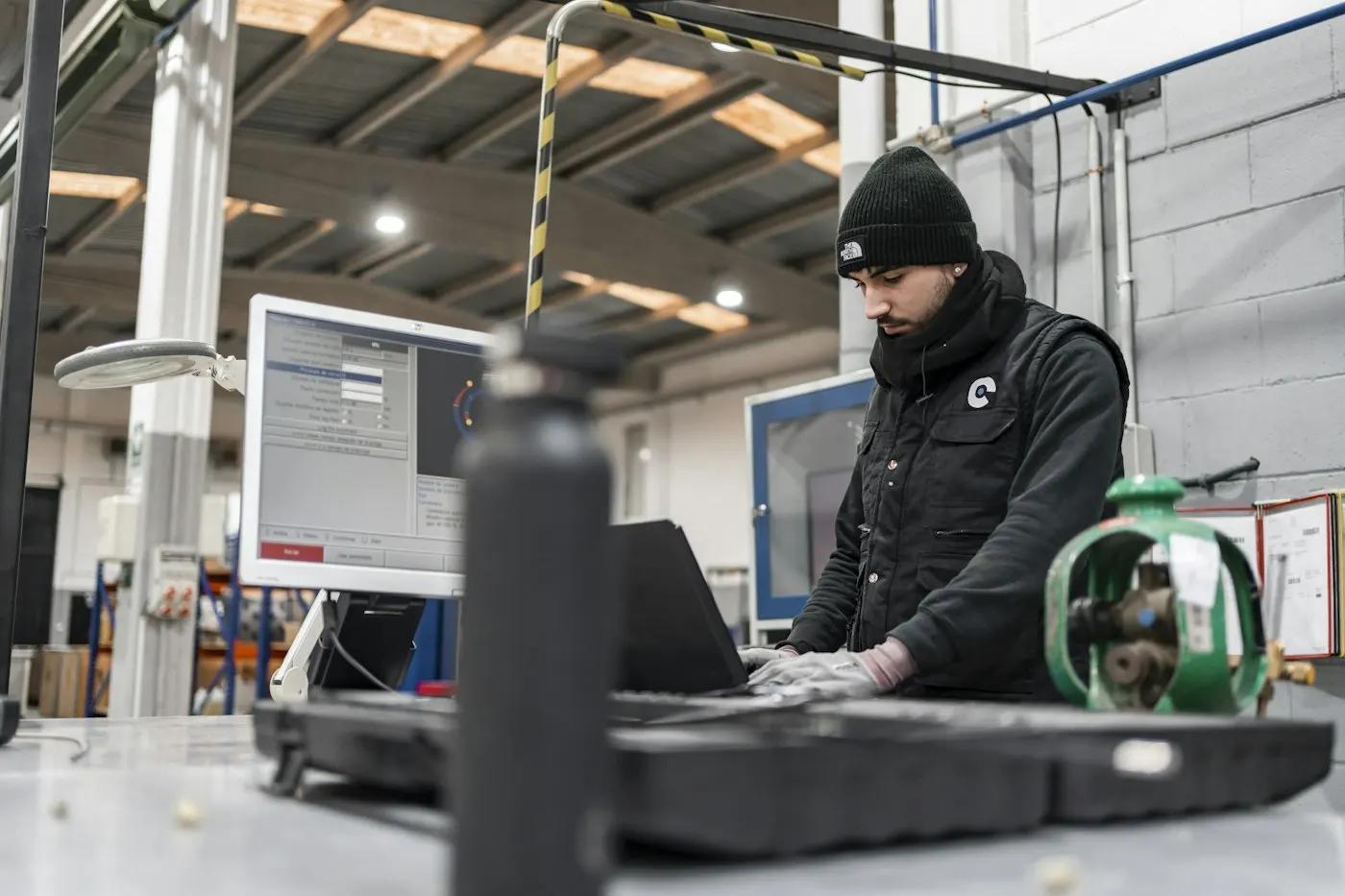 Mitarbeiter in einem Produktionsbetrieb sucht am Rechner nach Informationen